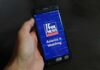 On-Air ‘Gay-Shaming’ Sparks Fox Uproar hand holding smartphone with Fox News app open