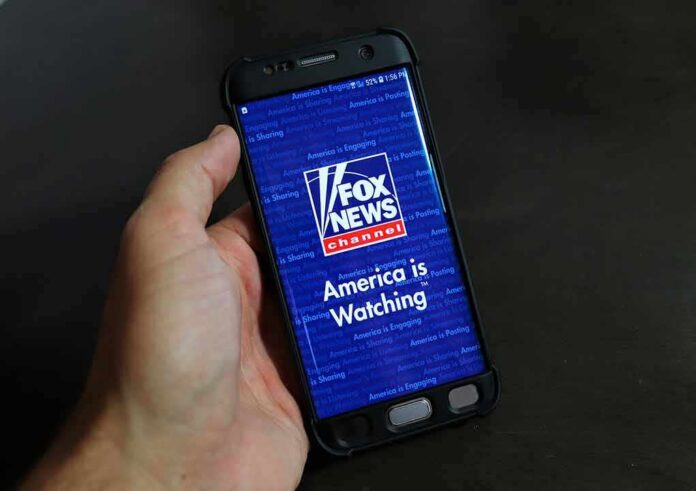 shutterstock_1780457417 hand holding smartphone with Fox News app open