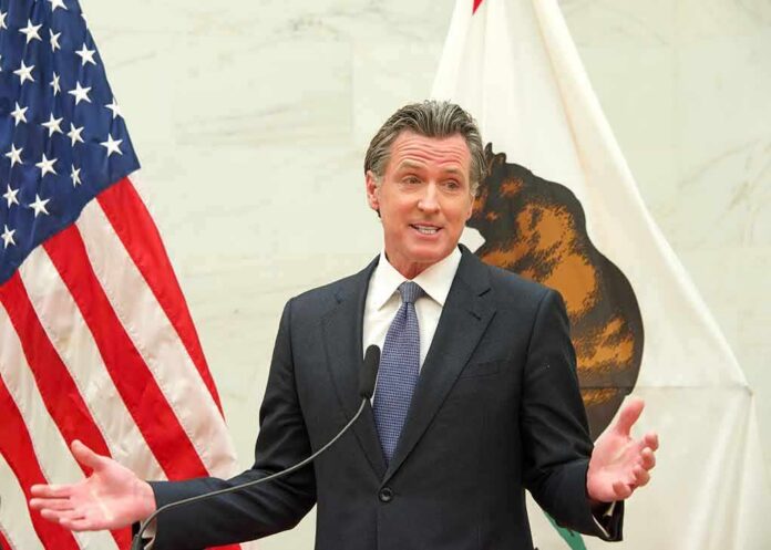shutterstock_2150653889 man in suit speaking at podium between U.S. and state flags