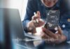 AI Slashes Costs — Startups Explode Person using smartphone with chat bubbles and laptop