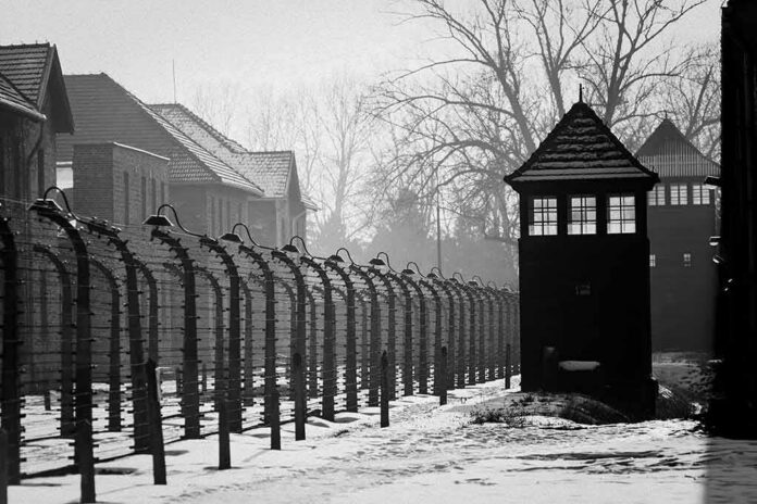 shutterstock_575253622-2 Guard tower and barbed wire fence in a snowy compound