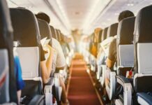 Free Upgrades DOWNSIZED on Key Routes Airplane cabin aisle with passengers seated