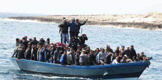 Crowded blue boat carrying many people on the sea
