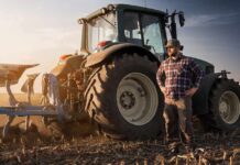 Farm Crunch Deepens As Diesel Soars Farmer standing beside a tractor in a plowed field