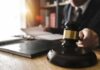 Lavish Life on Fake Truck Cash – Grand Jury Hits Alleged Fraud King Judge's gavel on desk with person reading documents in background