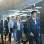 Business team walking through modern glass-walled office