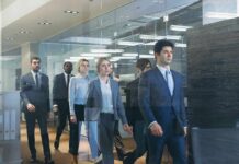 LinkedIn Data Stuns: AI Wave Gut-Punches Women Business team walking through modern glass-walled office