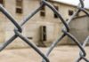 Chain-link fence with blurred concrete building behind