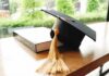Graduation cap with gold tassel on a book