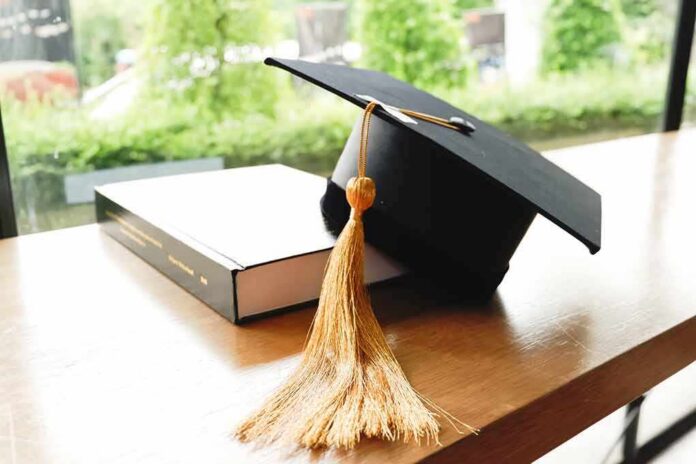 Graduation cap with gold tassel on a book