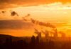 Power plant cooling towers emit smoke at sunset