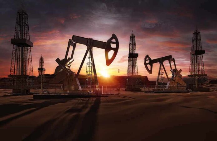 shutterstock_1667830870 Oil pumpjacks and derricks at sunset in a desert field