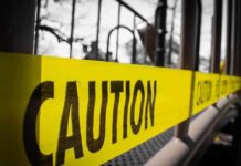 Yellow caution tape stretched across a metal playground structure