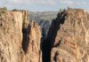 Steep canyon cliffs with a narrow chasm and scattered pines