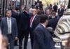 High-Stakes Gracie Mansion Meeting Donald Trump waving while surrounded by security personnel on a city street