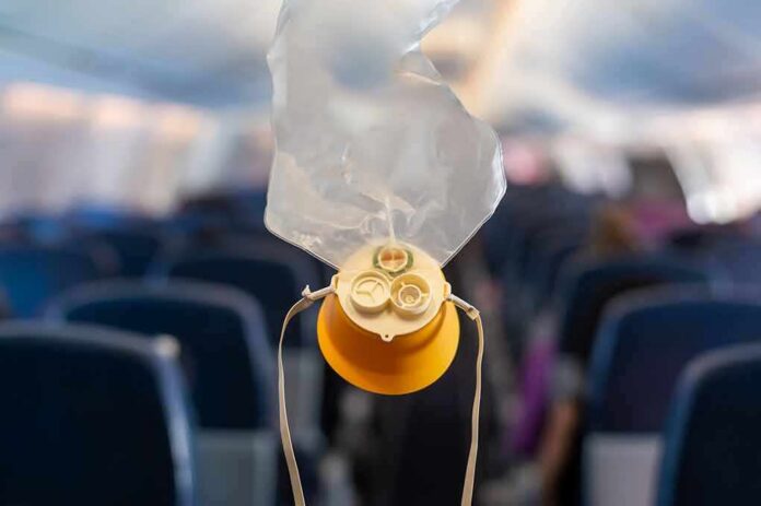 shutterstock_2284957561 airplane oxygen mask hanging in cabin aisle