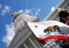 Newsom’s Security—On Motorists’ Dime California state flag in front of a white domed capitol building