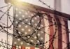American flag behind barbed wire