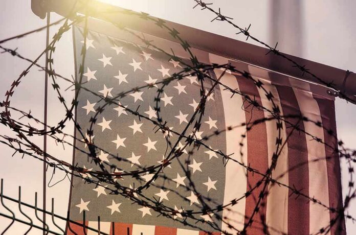 American flag behind barbed wire