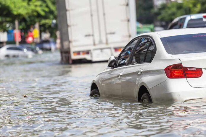shutterstock_734475445 Silver car partially submerged in floodwater