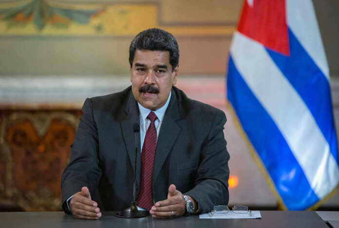 1102291202-2 Nicolás Maduro speaking at a podium with a microphone