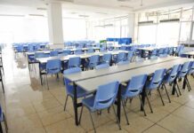 Teen Terror Plot Alleged – School Lunch Turns Into Hazmat Nightmare Empty cafeteria with rows of blue chairs and long tables