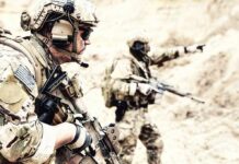 Camp Buehring Hit – Troops Bolt Soldiers in camouflage gear with rifles in a sandy terrain