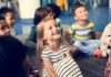 60 Million Kids Auto-Enrolled – Guess Who Group of children sitting on a classroom floor smiling