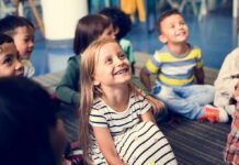 Group of children sitting on a classroom floor smiling