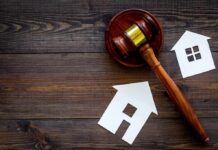 Receipts Or Ruin: New Housing Crackdown Judge's gavel with paper house cutouts on wooden table