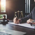 Surveillance Creep: Norway Targets AI Glasses Lawyer writing at desk with gavel and scales