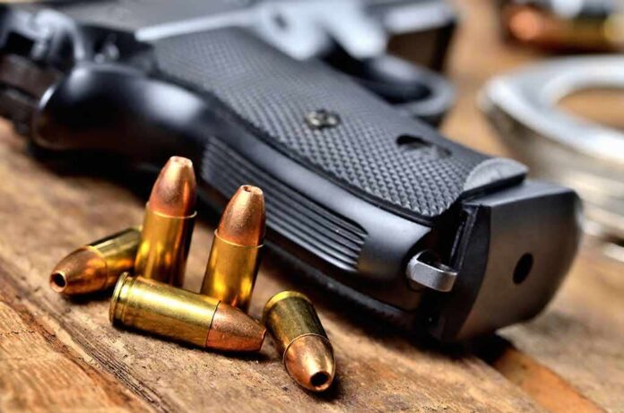 shutterstock_1146346211 Handgun with scattered bullets on wooden surface