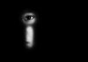 face peering through a keyhole in darkness