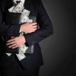 Bribery Trail? Senator Tied To Weed Empire Businessman hugging briefcase stuffed with cash