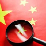 College Crackdown: Hidden China Hubs Exposed Magnifying glass over the Chinese flag