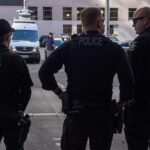 Police officers stand on a city street