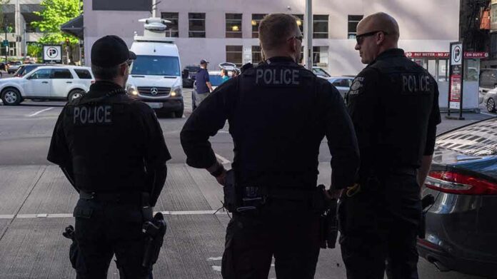 shutterstock_1386794081 Police officers stand on a city street