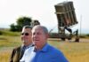 Ehud Barak and another man outdoors near a missile defense battery