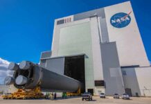 NASA Rock Shakes Solar Origin Story Rocket stage moved on transporter outside large NASA assembly building