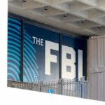 FBI sign on building facade behind metal fence