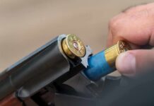 Close-up of shotgun being loaded with blue shells