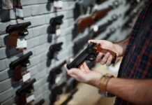 Gun Shop Panic: Chilling ICE Threats – Lawyer Nabbed Fast Person holding a handgun in a gun shop