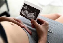 Taxpayer Tab for IVF? Grindr’s Gamble Pregnant person holding an ultrasound photo over their belly