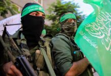 armed men in green headbands holding a green flag