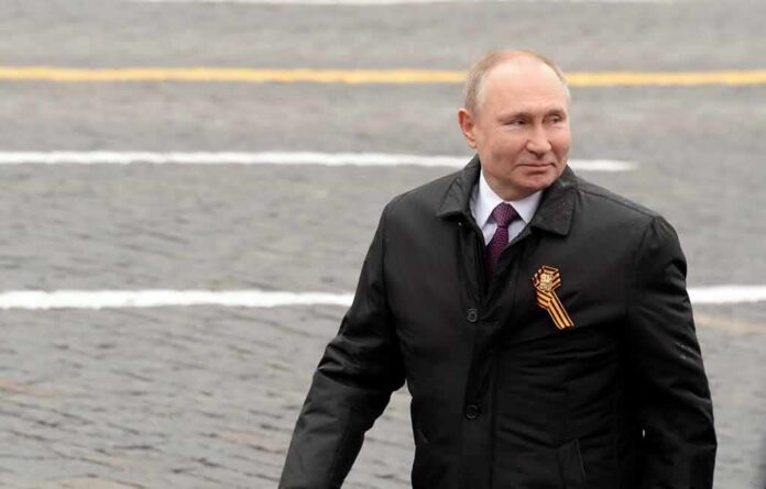 man in dark coat with ribbon walking outdoors