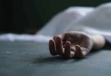 human hand lying on floor under white sheet