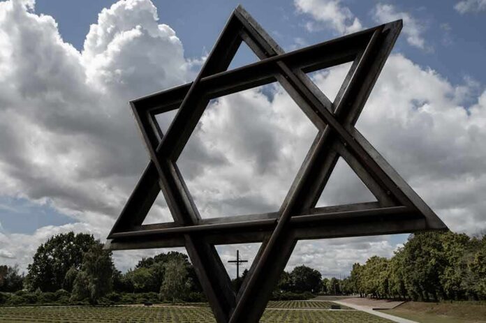 Large Star of David sculpture in a park under cloudy sky