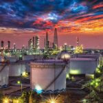Gulf Flows Back – Hormuz Jitters Keep Gas Pain High Oil refinery with storage tanks at sunset