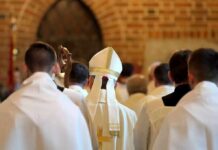 Faith Flip? Doctrine Blur Warning Rocks Italy Bishop in white mitre among clergy during church procession