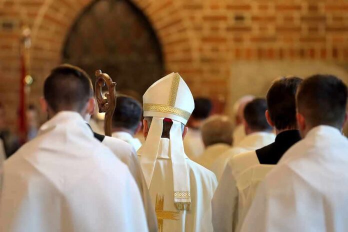 shutterstock_653291812-2 Bishop in white mitre among clergy during church procession